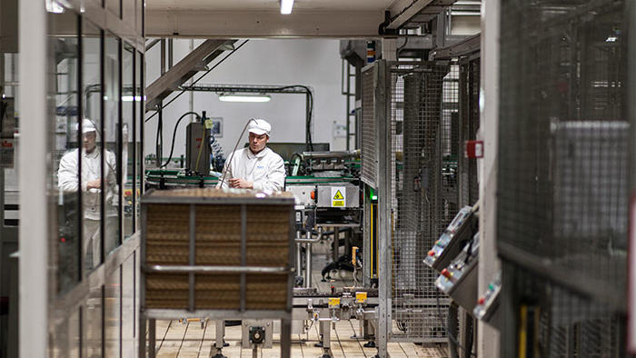 Співробітник заводу Hero працює в приміщенні зі світлодіодними світильниками Philips для об’єктів харчової промисловості