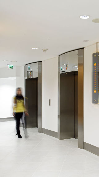 Коридор и лифты в здании Tower 42, освещенные с применением офисных световых решений Philips