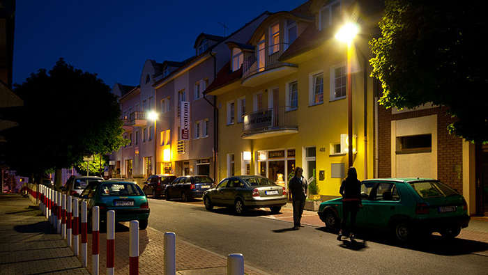Люди гуляют по ночной улице, освещенной компанией Philips 