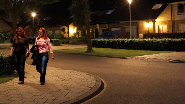 Две женщины идут по улице, освещенной белым светом от Philips