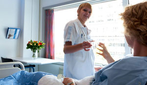 Медсестра пропонує пацієнту склянку води