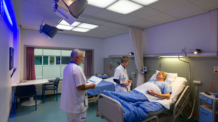 Врачи лечат пациента в палате, освещенной при помощи системы Philips Healwell