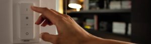 «Ручний світлодіодний димер Philips, що регулюється вручну, керує освітленням у затишній вітальні з книжковими полицями».